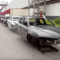 Karoserie Alfa 159 připravené k osazení se válí všude možně po areálu továrny.