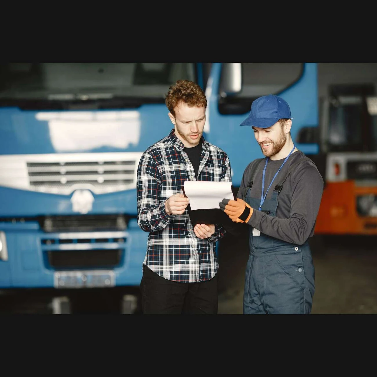 Zákazník s mechanikem kontrolují dokumenty k opravě